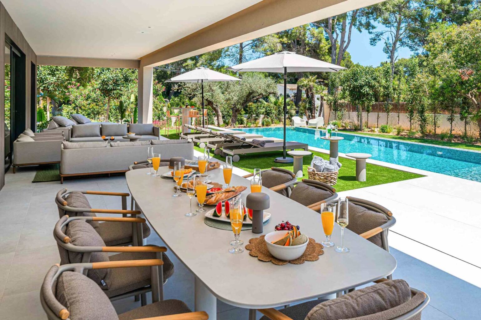 Breakfast table with fresh juice beside the pool at Gotmar Beach villa, Puerto Pollensa