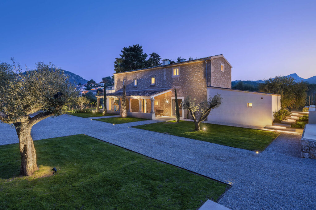 Villa Antigua stone façade and olive trees lit at dusk, Pollença, north Mallorca