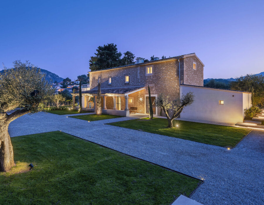 Villa Antigua stone façade and olive trees lit at dusk, Pollença, north Mallorca