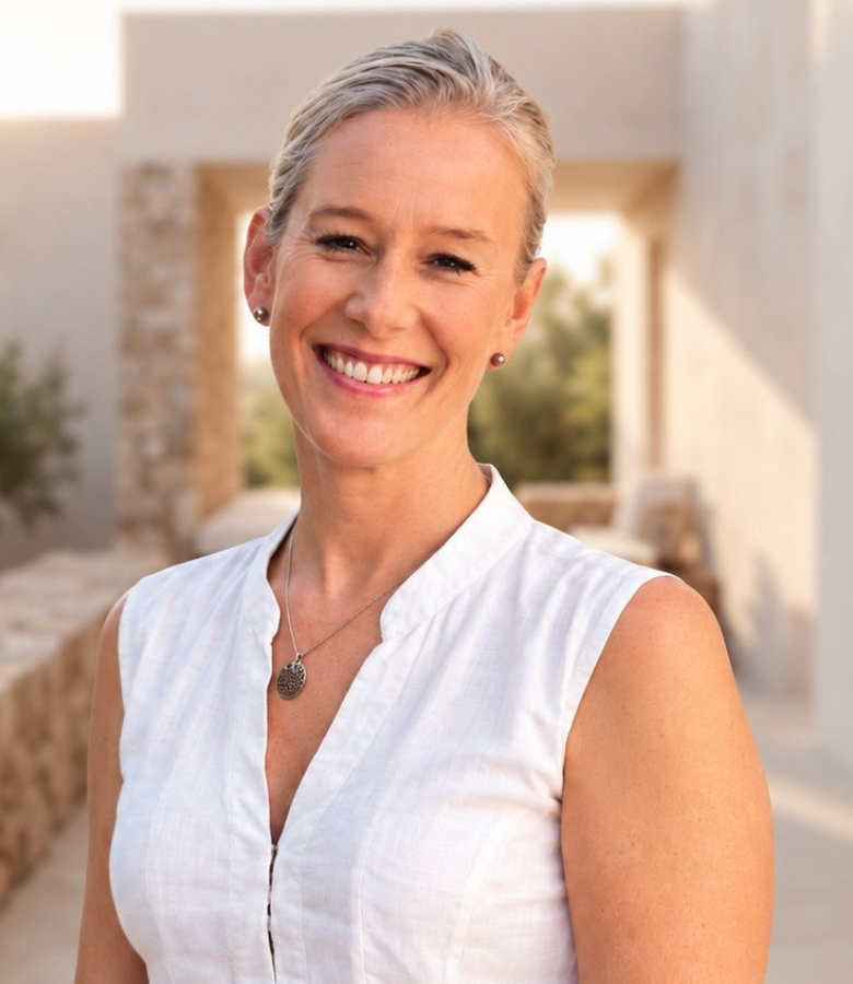 Iris, the host behind Pollensina, smiling on a sunlit terrace in Pollensa, Mallorca